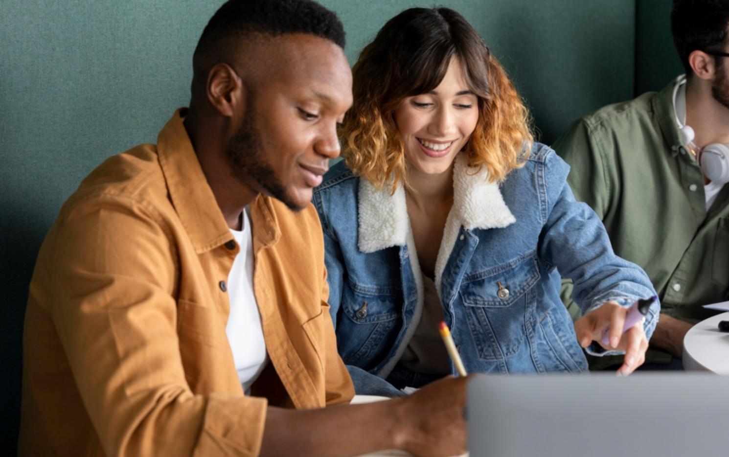 Teilnehmer arbeiten gemeinsam an einer Budgetanalyse mit verschiedenen Dokumenten und Laptops